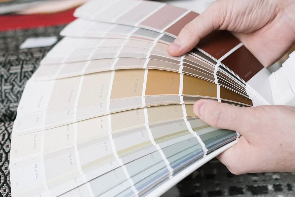 Mão segurando um leque de amostras de cores